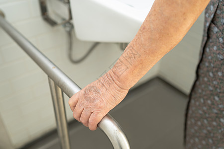 亚洲老年或老年老太太妇女病人在护理医院病房使用厕所浴室手柄安全 健康强大的医疗理念医院汽车浴缸酒店老年人洗澡金属栏杆铁轨洗手间图片