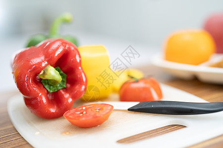 红铃甜辣椒和番茄 切餐板上有刀 蔬菜沙拉 烹饪健康食品图片