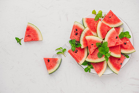 夏日时盘子上的新鲜切片西瓜白色甜点食物饮食营养水果绿色桌子红色图片