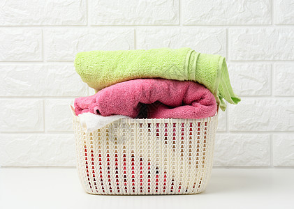白色架子 浴室室内的塑料篮里 干净的滚毛巾洗衣店家庭柔软度酒店毛巾纺织品折叠棉布篮子织物图片