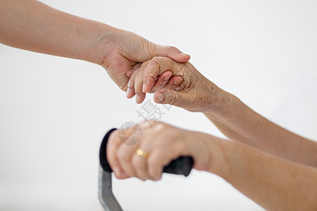 家中使用拐杖和照顾者照顾的老年女性老人保健长老机动性帮助祖母卫生退休女人甘蔗残障图片