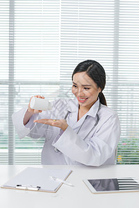女医生微笑地看着她 手里拿着一盒药箱电脑药片药剂师医疗工作医院化学女性治疗桌子图片
