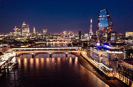 美丽的伦敦市的夜景 城市建筑桥与摩天大楼和海洋水周围的小建筑物相距很远 环绕着洋图片