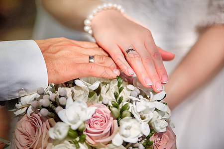 新郎和新娘的手幸福女士戒指裙子仪式花朵金子夫妇叶子男人图片