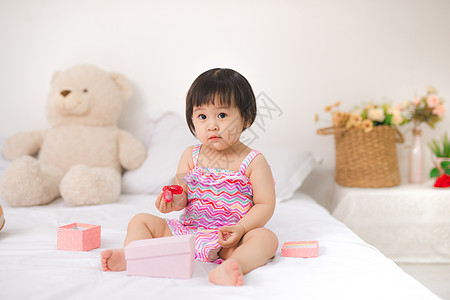 小可爱的亚洲女婴 坐在床上玩图片