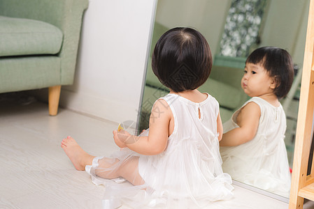 坐在地板上玩耍的小可爱的亚洲女婴图片