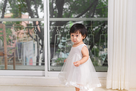 小可爱的亚洲女婴 在家窗户旁边玩耍图片