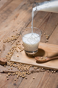 豆类牛奶或大豆和豆子 放在木制桌上的勺子上豆浆食物木头种子营养飞溅白色玻璃黄色饮料图片