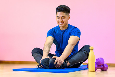 西班牙年轻人在健身房的垫子上 以粉红色背景做瑜伽运动训练运动员姿势成人练习身体体操拉丁力量图片
