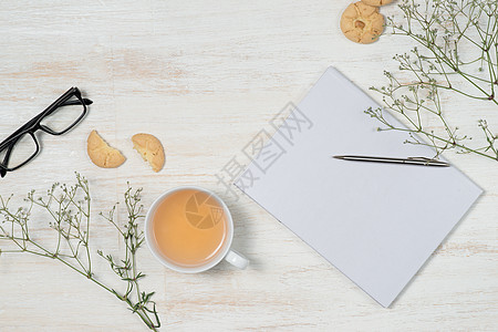 工作桌最顶端视图 空白笔记本 带钢笔 咖啡杯 移动电话和木背景的饼干图片