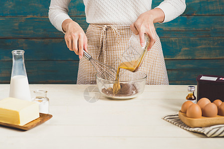 家庭主妇穿着围裙 做巧克力蛋糕的步骤 准备面粉 混合配料和食品蛋糕面团女士女儿妈妈母亲女孩框架烘烤父母图片