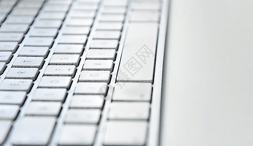 白色桌子上脏兮兮 满是灰尘的现代白色电脑键盘的细节网络电子产品钥匙外设工作办公室空格键硬件技术金属背景图片