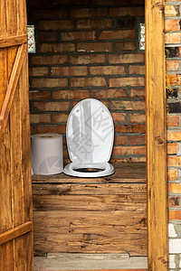 一个简单的乡村厕所 里面有一大卷卫生纸 厕所里有大卷卫生纸建筑木头木板村庄地面房间衣柜卫生座位农村图片