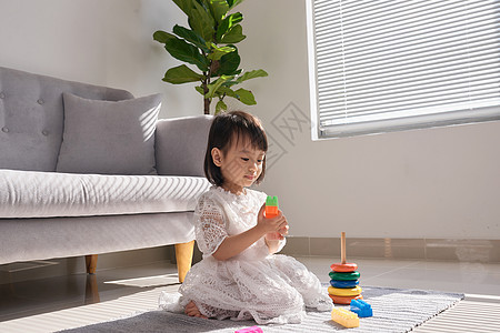 在家里的地板上玩建筑砖的小可爱女孩 在地上玩托儿所意义童年建筑染色教育玩具孩子积木幼儿园图片
