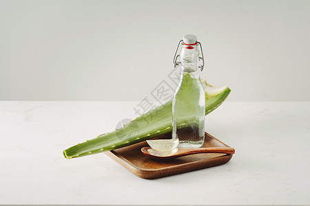 白色背景上的 Aloe 片件 新鲜叶子和瓶玻璃图片