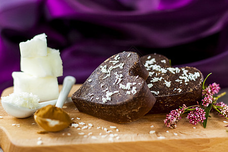 桌子上有由椰子油 椰子薯片和可可制成的手工巧克力 甜点根据适当营养的食谱制成美食香气乡村艺术木头心形糖果盘子装饰风格图片