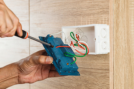 电工用螺丝起子把电线绑在插座上电气插头技术力量建筑金属服务电路劳动者房子图片