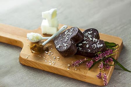桌子上有由椰子油 椰子薯片和可可制成的手工巧克力 甜点根据适当营养的食谱制成装饰盘子艺术木头烹饪风格美食棕色乡村香气图片