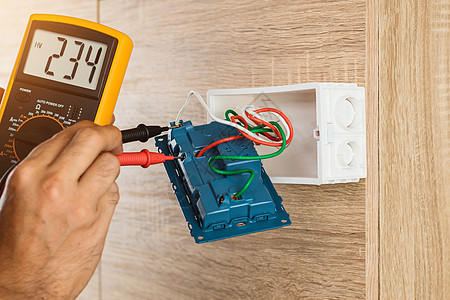 电工用数字仪测量木墙壁插座的电压 在高空上职业安全工程师建筑安装劳动者电缆仪表出口房子图片