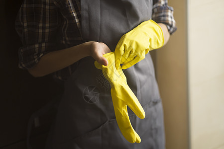 穿黄色橡皮手套的妇女做家务女性抛光家庭消毒衬衫清洁工家务房子化学品灰尘图片