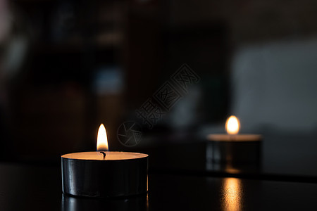 黑暗中一根小蜡烛的火焰庆典黄色瑜伽黑色冥想芳香辉光戒指浪漫烛光图片