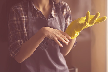 穿黄色橡皮手套的妇女做家务家政卫生女士灰尘消毒房子家庭海绵工艺女性图片