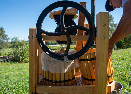 一个男人用传统水果机 和飞轮做苹果苹果汁图片