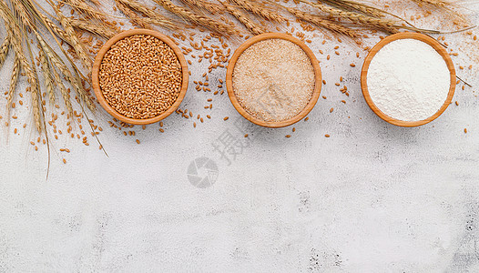 小麦 棕色面粉和在白混凝土底料上安装的木碗中的白面粉养分地面谷类燕麦化合物麦片味道糕点大麦饮食图片