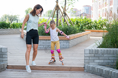 白种女人教她的女儿滑雪滑冰 笑声平衡帮助活动运动刀刃母性童年母亲拥抱学习图片