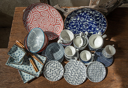 木桌上不同的陶瓷板碗和杯子热情潮人盘子筷子材料木头手工收藏装饰风格图片