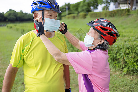 身戴医疗面具和在公园骑自行车的亚裔老年夫妇夫妻骑术微笑运动闲暇保健卫生妻子丈夫口罩图片