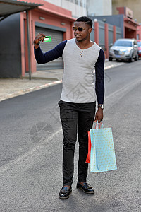 青年男子在户外携带购物袋购物信用卡幸福顾客市场衣服零售城市店铺快乐图片
