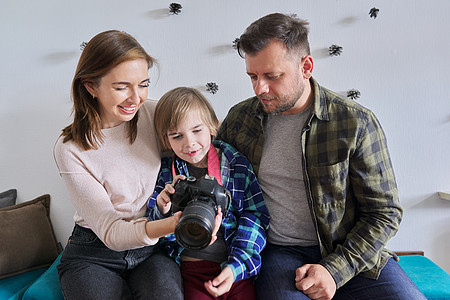 在家快乐的一家人 小儿子和爸爸妈妈带照相机儿子拥抱妻子女士丈夫母亲童年男人孩子夫妻图片