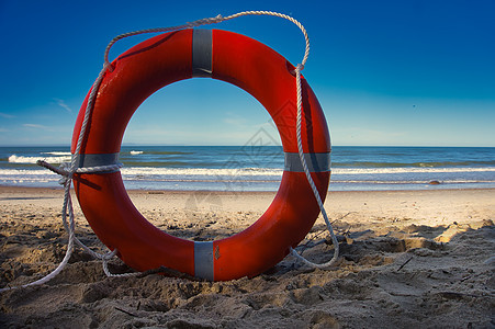 红色救生戒指站在沙滩上图片