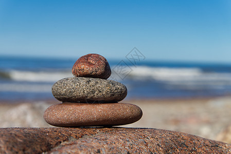 海滩上平衡的石头或岩石堆日落团体场景蓝色海洋治疗天空金字塔海岸冥想图片