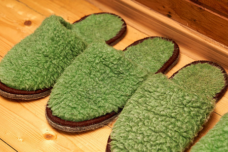 给走廊木地板上客人的绿色绿拖鞋房子文化配饰手工毛皮鞋类衣服家庭羊毛礼物图片