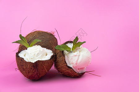 粉红色背景上用薄荷叶装饰的新鲜椰子半香草冰淇淋球异国情调产品树叶水果奶油叶子牛奶味道食物图片