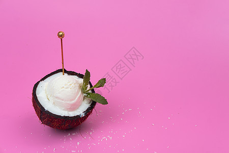 新鲜椰子中的香草冰淇淋球 一半用薄荷叶装饰 粉红色背景上有勺子味道薄荷树叶水果情调食物异国奶油产品叶子图片