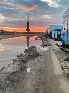 一油田 有石油钻机和货车 日落时在水坑中反射生产建筑生态钻孔化石管道油井工地技术天空图片