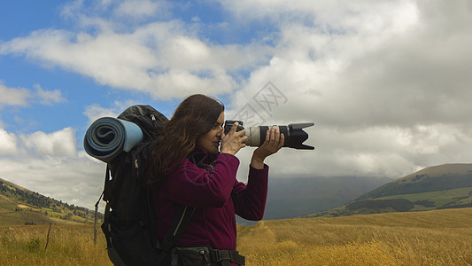 近距离接近一个美丽的西班牙女侦察员 一个背包用远光镜头拍照的手背背包旅行相机旅游场地游客照片天空摄影师女性冒险图片