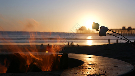 美国加利福尼亚州的篝火坑 在海洋海滩上营火 在篝火上烤吐司棉花糖海洋戒指码头烹饪支撑海景营火海滩烧烤波浪图片