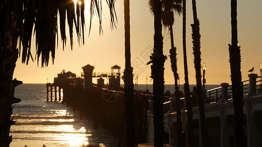 在美国加利福尼亚州 有人在木码头上行走 在海边的旅游度假胜地码头电影摄影海洋人群气氛日落阳光海景假期图片