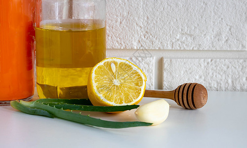 砖背景白桌上的天然感冒药 大蒜 蜂蜜 柠檬 芦荟治疗秋季感冒 covid 19 的民间疗法图片