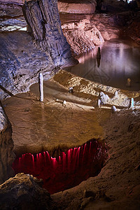 山洞中的瀑布和瀑布 被红灯冲入更深的洞穴图片
