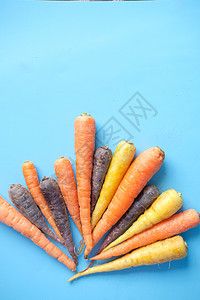 蓝色背景上的混合彩色胡萝卜饮食植物黄色团体蔬菜营养黑色食物橙子果汁图片