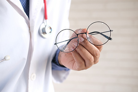 医生用手把一副黑色眼镜给病人眼睛服务框架阅读光学焦点卫生验光师男性治愈图片
