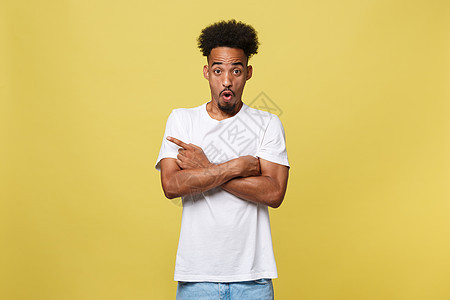 年轻英俊的非裔美国人 在黄色背景上向上走去黑色手指青年男性广告工作室成人灰色微笑男人图片