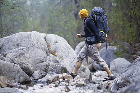 一个带着背包的年轻笑脸男人冒险旅游远足者运动游客远足旅行男性娱乐悬崖图片