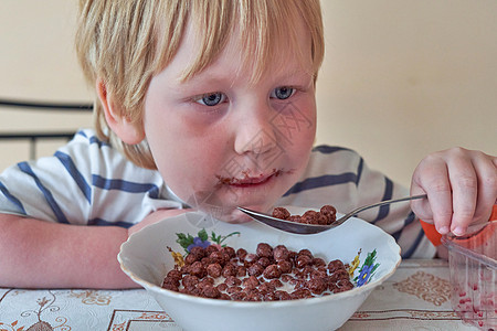 小男孩正在吃早餐 巧克力球和牛奶的巧克力球粮食食品可可小吃谷物小麦健康饮食勺子男生食物图片