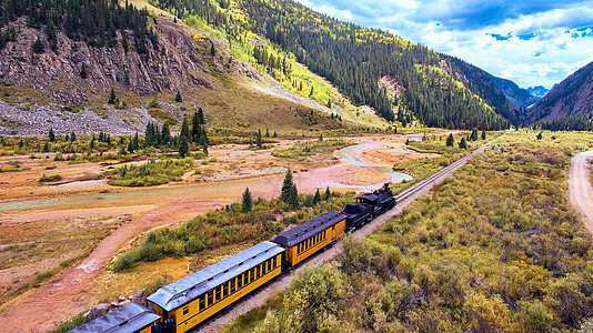 旧黑列车 煤炭穿过山谷 周围山峰环绕图片